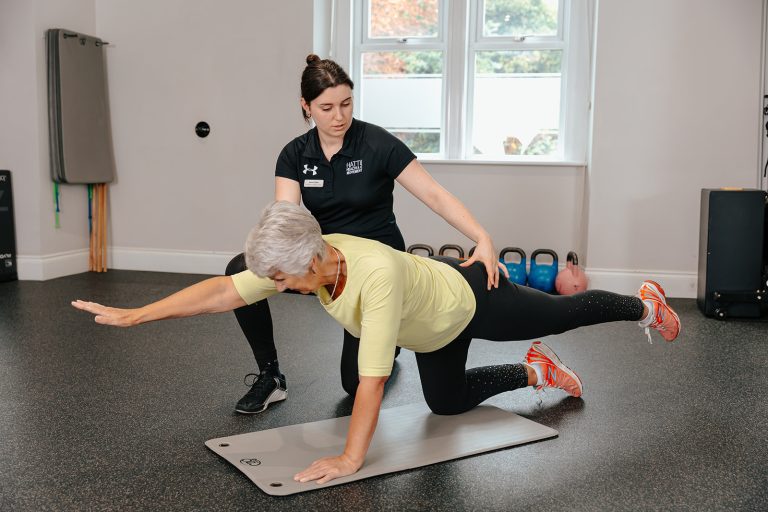 Team member helping woman stretch