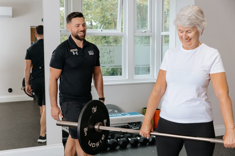 Trainer watches Woman lifting weight