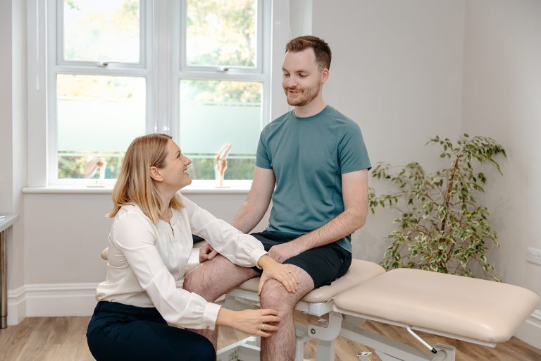 Patient receiving knee treatment from physiotherapist