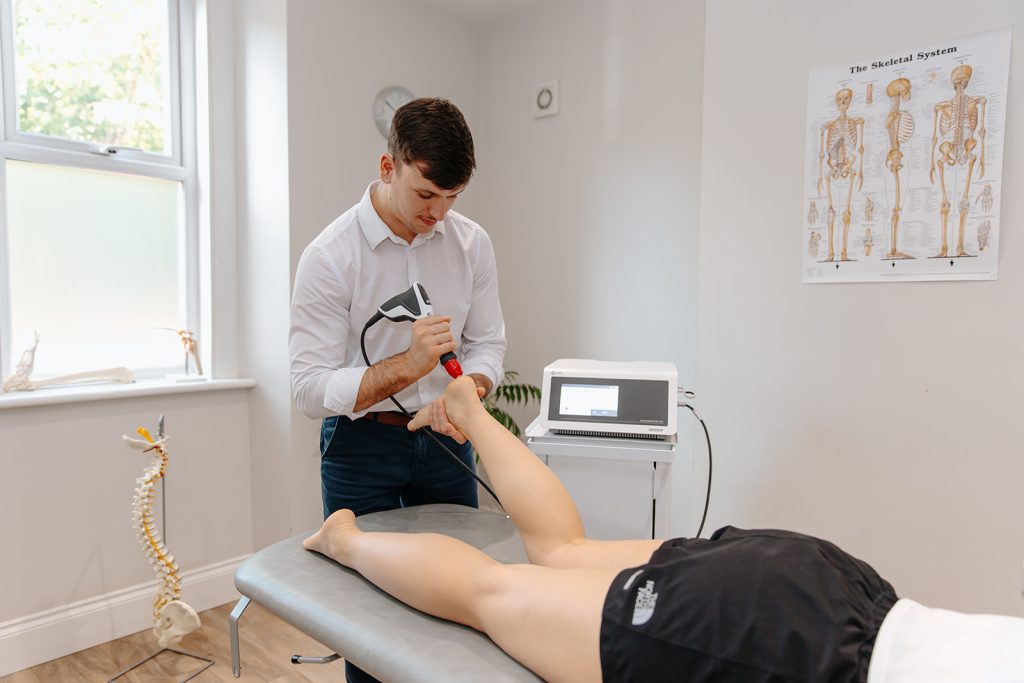Physiotherapist applies Shockwave Therapy on patients foot