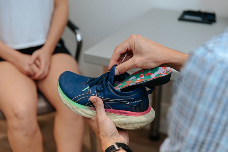 Rehab therapist inserts Orthotic into shoe