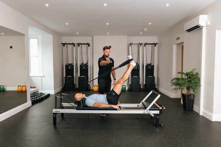 Man participating in Reformer Pilates at the Hatt Clinic