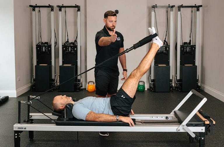 Man using stretch machine during Pilates class