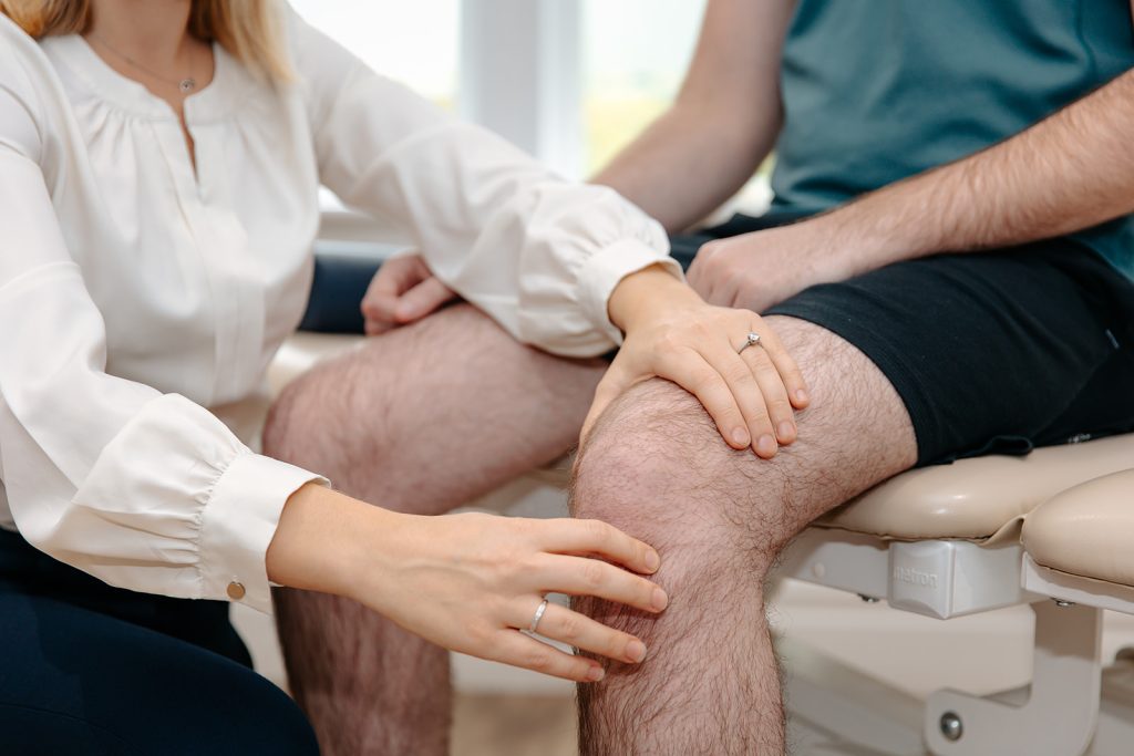 Physiotherapist treating patients knee