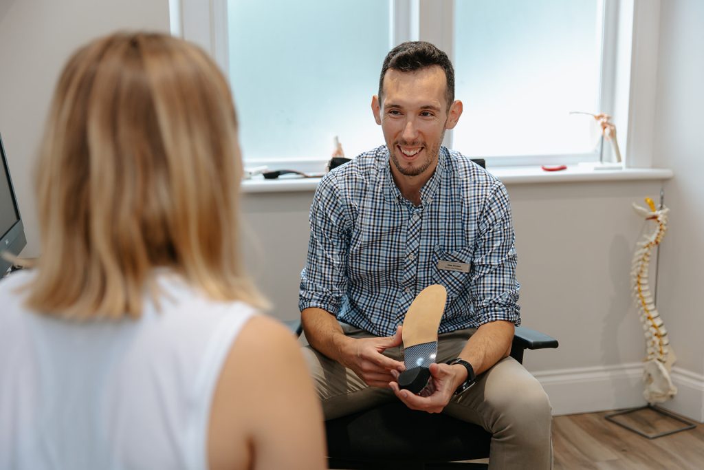 Physio showing orthotic to patient