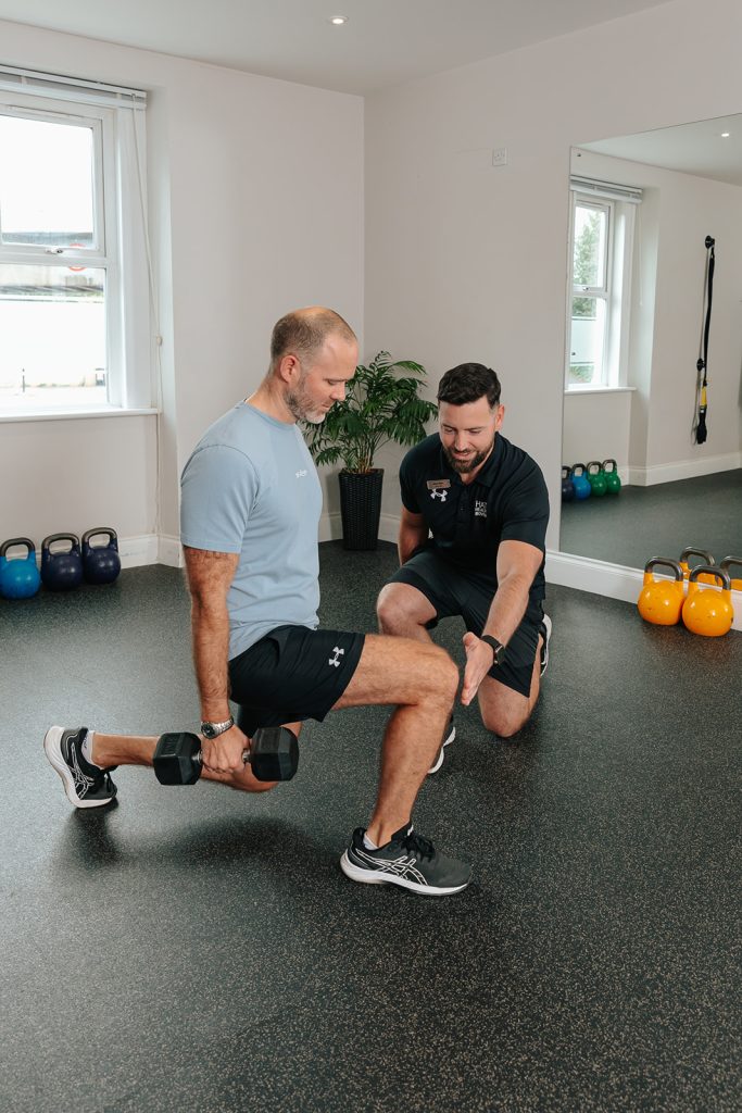 Man doing lunges whilst holding weights