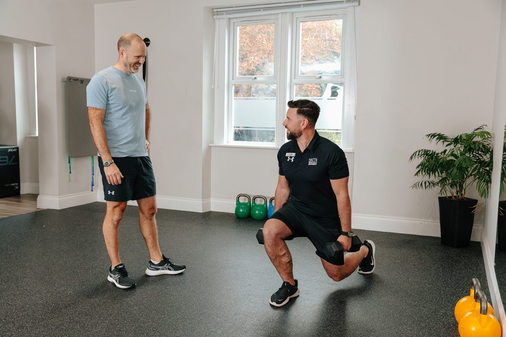 Man doing lunges whilst holding weights